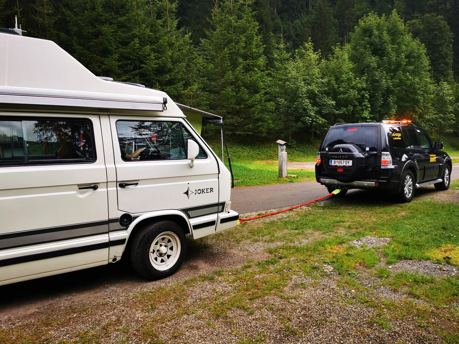 Einsatzfahrzeug der Walserwerkstatt zieht einen liegengebliebenen Bus aus einem Waldweg